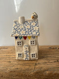 Small porcelain tea-light house, daisies, pastel (light blue) with gold detail
