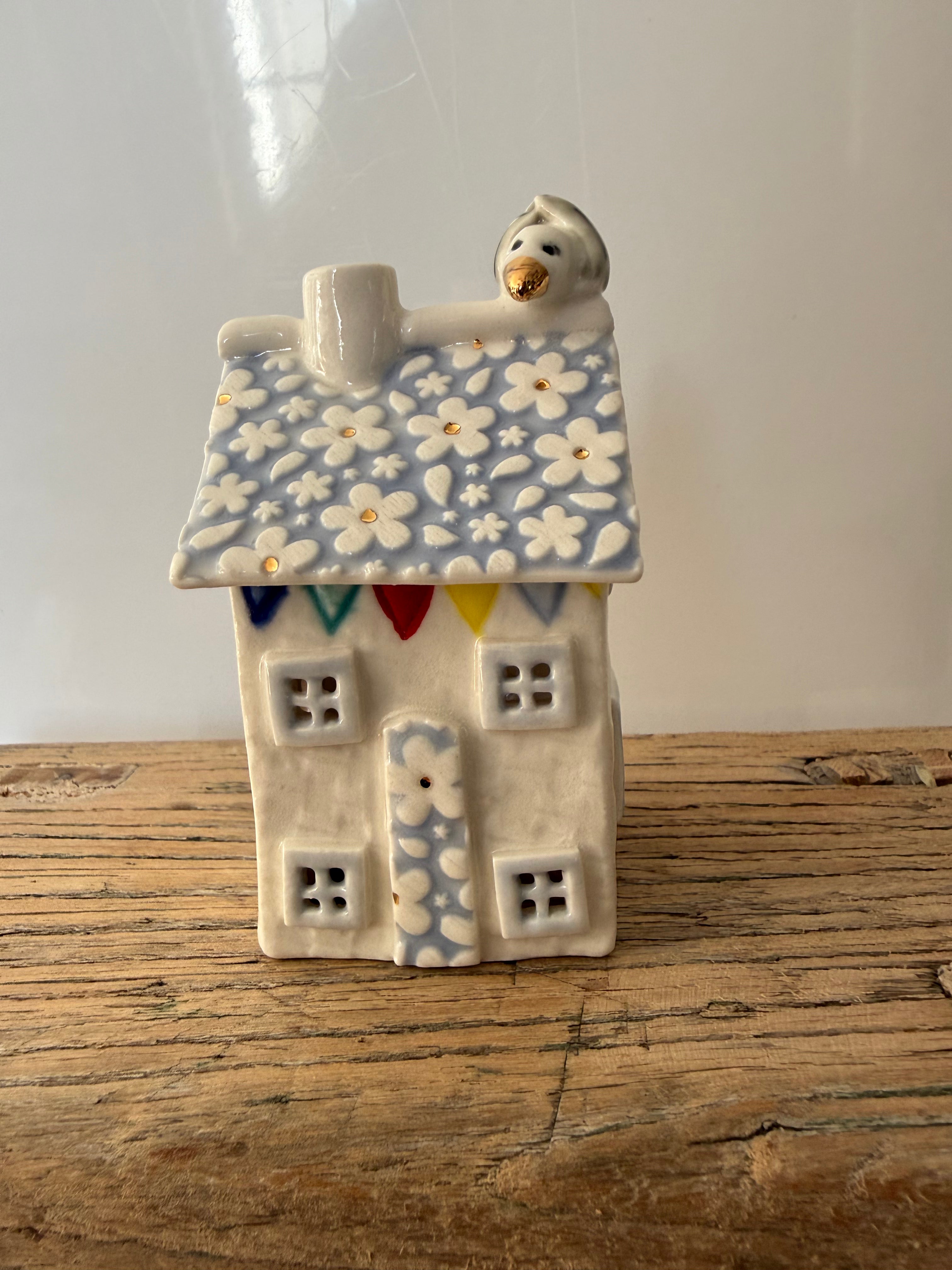 Small porcelain tea-light house, daisies, pastel (light blue) with gold detail